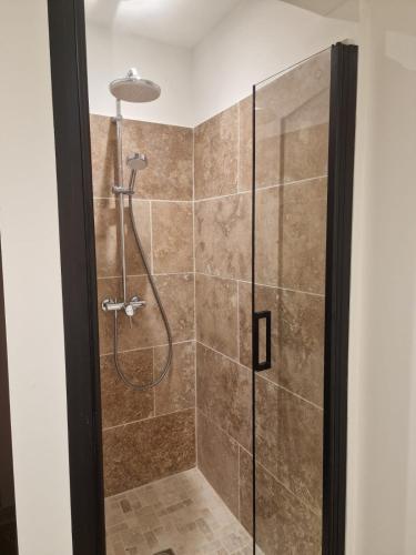 une salle de bain avec une douche avec une porte vitrée dans l'établissement Domaine du Mas Foucray, aux Baux-de-Provence
