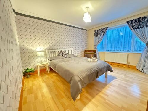 a bedroom with a large bed with blue curtains at Two Double Bedroom Maisonette with rear garden. 