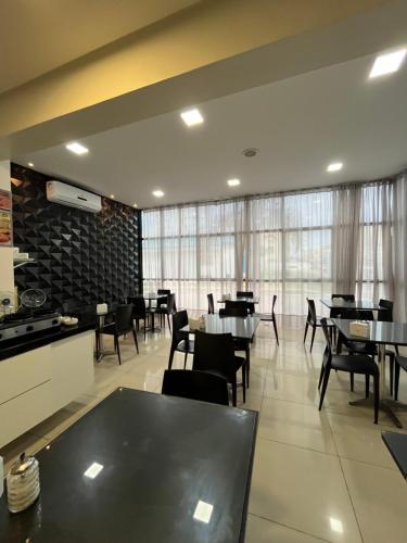 - une salle à manger avec des tables, des chaises et des fenêtres dans l'établissement Mcz Hotel, à Maceió