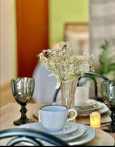 a table with a vase of flowers and a cup of coffee at Espaço da Zilda in São José
