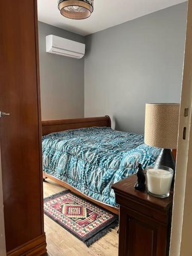 a bedroom with a bed and a table with a lamp at Le cocon d'Ali in Langon