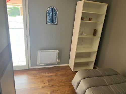 a room with a book shelf and a fan at Le cocon d'Ali in Langon