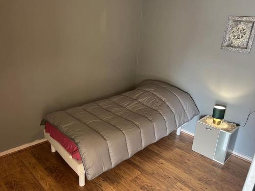 a small bed in a corner of a room at Le cocon d'Ali in Langon