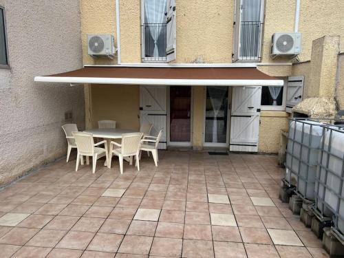 a patio with a table and chairs and a building at Le cocon d'Ali in Langon
