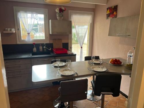 a kitchen with a table with wine glasses on it at Le cocon d'Ali in Langon