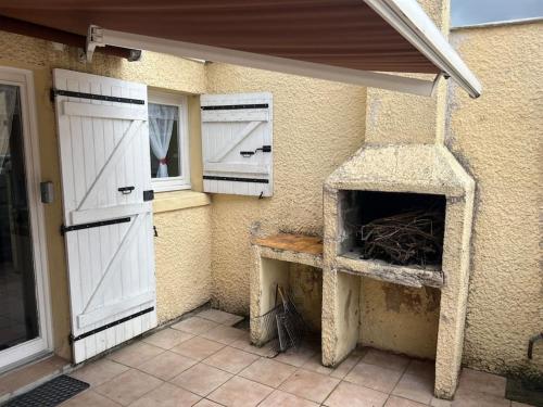 a building with a stone fireplace in a patio at Le cocon d'Ali in Langon