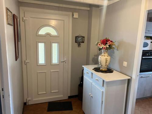 a vase of flowers on a counter next to a door at Le cocon d'Ali in Langon