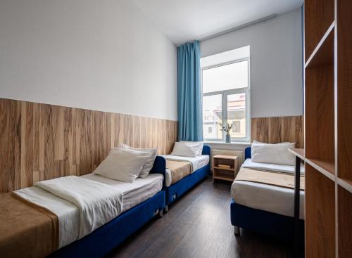um quarto de hotel com duas camas e uma janela em Отель РиверСайд Невский em São Petersburgo