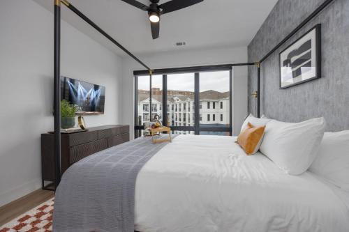 Vesta - Odyssey - Heart of Midtown في ناشفيل: غرفة نوم مع سرير أبيض كبير مع نافذة كبيرة