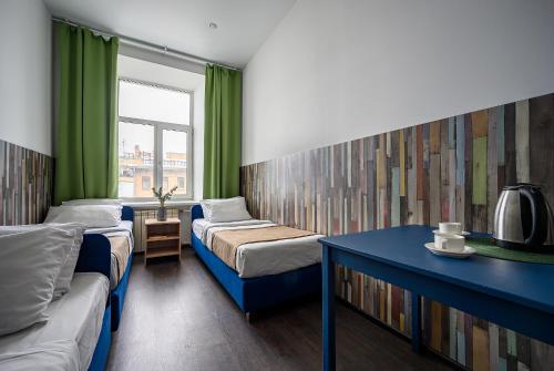 um quarto com duas camas e um sofá e uma janela em Отель РиверСайд Невский em São Petersburgo