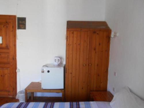 a bedroom with a small refrigerator and a table at Sotos pension in Skopelos Town