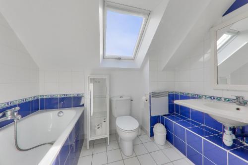 a blue and white bathroom with a toilet and a sink at Détente et vue sur le port à Arzon in Arzon