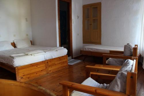 two beds in a room with wooden floors at Sotos pension in Skopelos Town