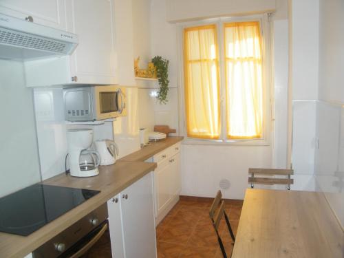 une petite cuisine avec une table et un micro-ondes dans l'établissement Apartment Villa HenriIV, à Nice
