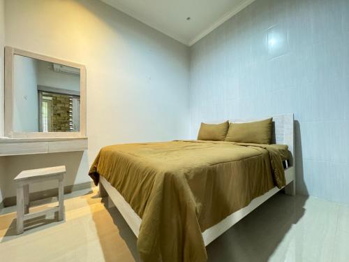 ein Schlafzimmer mit einem Bett mit einem Spiegel und einem Stuhl in der Unterkunft Villa Kelapa Gading Dalung in Dalung