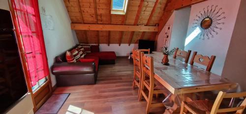 une salle à manger avec une table, des chaises et un canapé dans l'établissement Gîte de groupe La Gloriette, à Geu