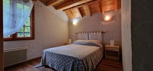 een slaapkamer met een bed en een raam bij Gîte de groupe La Gloriette in Geu