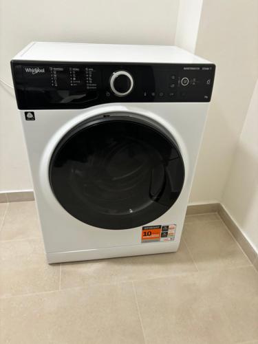 a white washing machine sitting on top of a floor at Parkside Apartments Praha in Prague