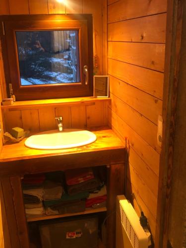 ein Bad mit einem Waschbecken und einem TV an der Wand in der Unterkunft Au croque nature in Soultzeren