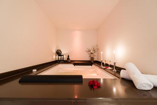 a bath tub in a room with towels and candles at Landhotel Burg im Spreewald - Resort & Spa in Burg
