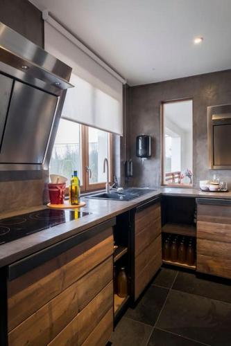 a kitchen with a sink and a stove top oven at Familie & Vriendenwoning met fantastisch uitzicht in Ellezelles