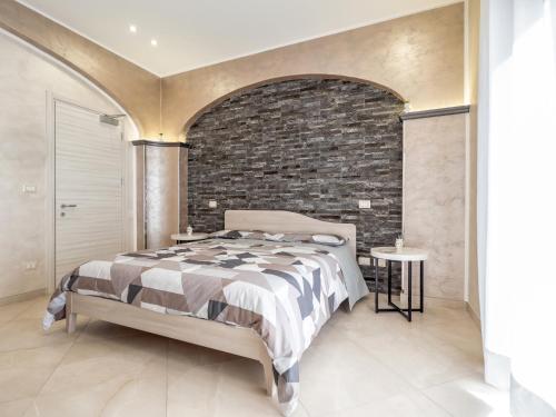 a bedroom with a bed and a brick wall at Eraldo Bed and breakfast in Cesarò