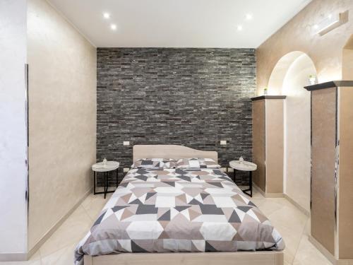 a bedroom with a bed and a brick wall at Eraldo Bed and breakfast in Cesarò