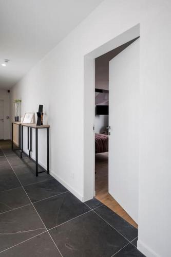 a room with a white wall and a tile floor at Familie & Vriendenwoning met fantastisch uitzicht in Ellezelles