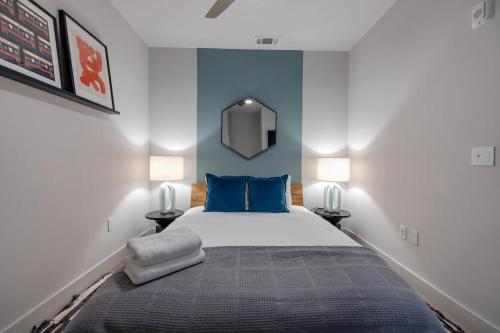 1 dormitorio con 1 cama con paredes azules y espejo en Wonderstruck - Odyssey - Heart of Midtown en Nashville