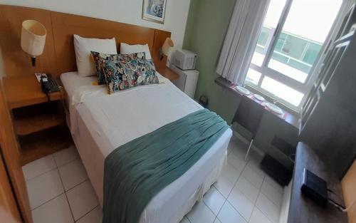 een kleine slaapkamer met een bed en een raam bij Sonia Flats Natal - No Apart Hotel Ponta Negra Beach in Natal