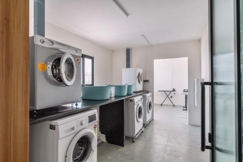 a kitchen with washing machines and a washer and dryer at SKYLA Studios & Suites - Kondapur in Hyderabad