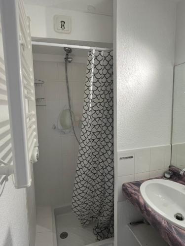 a bathroom with a shower and a sink at T2 - Les pieds dans le sables en toutes saisons 5 couchages - climatisation - parking privée - piscine - situation optimum et rare - Amoureva - Plage Richelieu- Cap d'Agde in Cap d'Agde
