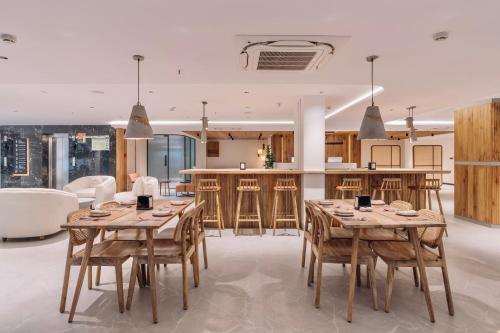 a kitchen and dining room with wooden tables and chairs at SKYLA Studios & Suites - Kondapur in Hyderabad
