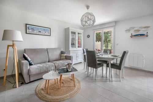 un salon avec un canapé et une table dans l'établissement Appartement dans résidence calme à 100m de la plage, à Saint-Brévin-les-Pins