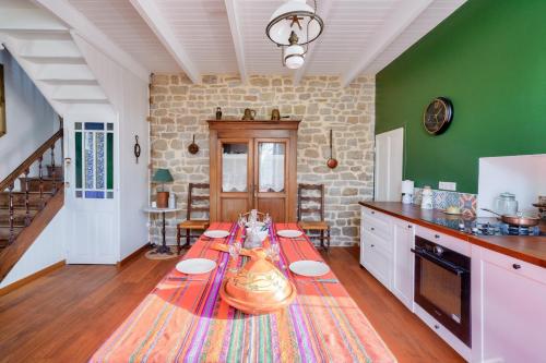 une cuisine avec une table au milieu dans l'établissement À 700m de la plage, charmante maison pour 6, à Penmarcʼh