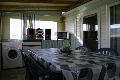 a dining room with a table with chairs and a kitchen at Chez Eponine in Dannes