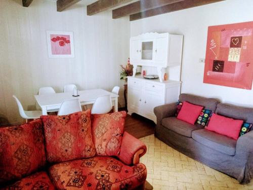 a living room with a couch and a table at Cottage by the Chateau with pool in National Parc in Les Salles-Lavauguyon