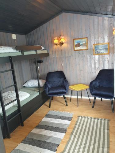 a room with bunk beds and a table and two chairs at Bjørgebu Camping AS in Mysusæter