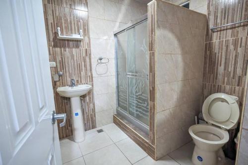 a bathroom with a shower and a toilet and a sink at Habitación a 5 min de la playa in San Felipe de Puerto Plata