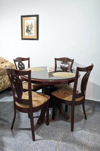 a dining room table with four chairs and a table at Habitación a 5 min de la playa in San Felipe de Puerto Plata