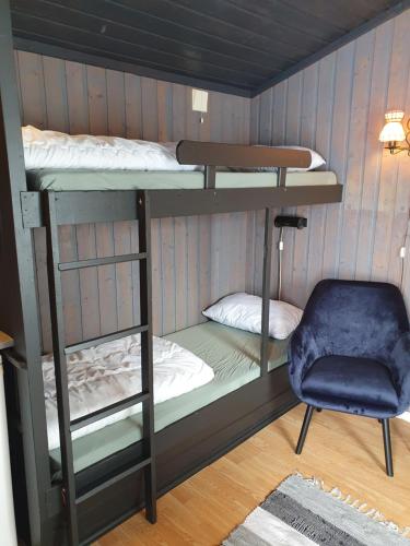 a room with two bunk beds and a chair at Bjørgebu Camping AS in Mysusæter