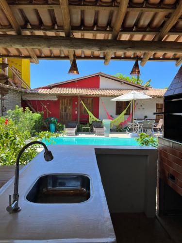 a kitchen with a sink and a swimming pool at Vila Uryah in Caraíva