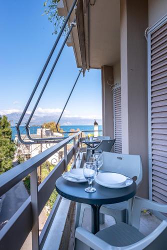 a table on a balcony with a view of the ocean at Selianitika Bay Apartment B1 in Selianitika