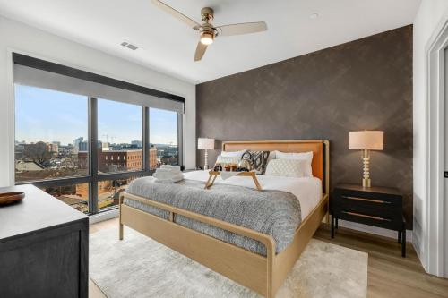 um quarto com uma cama e uma grande janela em Urban Cowboy - Odyssey - The Heart of Midtown em Nashville