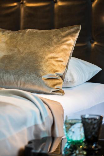 a bed with a brown pillow on top of it at hirschen dornbirn - das boutiquestyle hotel - skyrelax & wellness im rooftop in Dornbirn