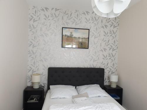 a bedroom with a bed and a picture on the wall at Les Gravelots in Saint-Vaast-la-Hougue