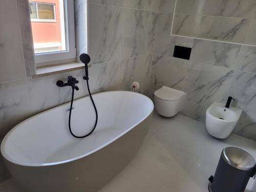 波爾蒂芒的住宿－HostelCCPortimão，白色的浴室设有浴缸和卫生间。