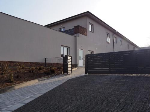 a white house with a black fence and a driveway at Apartmány Abacie in Nový Jičín