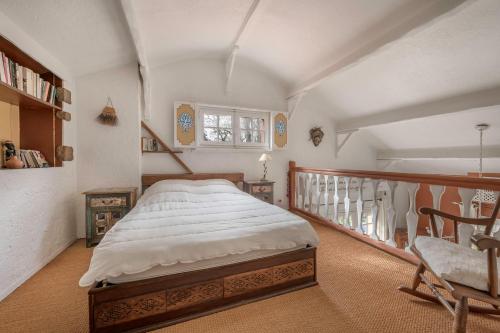 a bedroom with a bed and a chair in it at Maison pour 8 - proche plages in Mindin