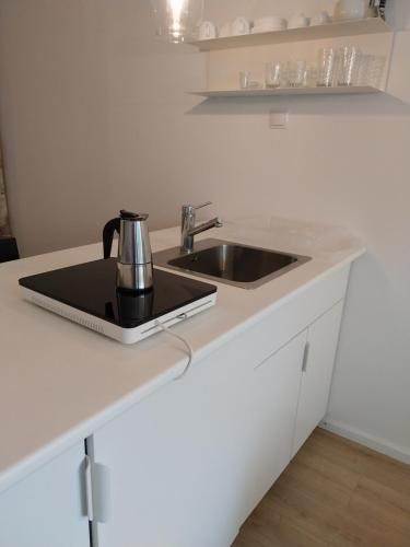 a kitchen counter with a sink and a coffee pot at Squash Apartments & Studios in Siófok